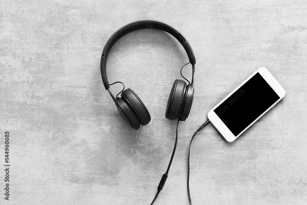 Headset and a phone on concrete background Headset and a phone on concrete background