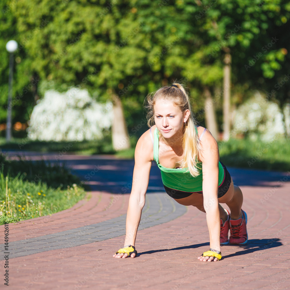 Young woman training in city park at summer day Young woman training in city park at summer day