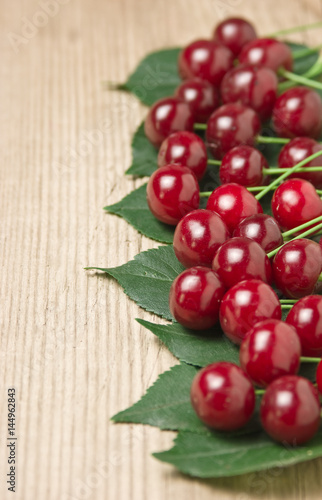 Berry Cherry with leaves on wooden background