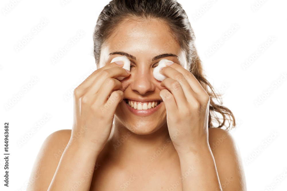 young woman cleans her face using tonic and cotton pads young woman cleans her face using tonic and cotton pads