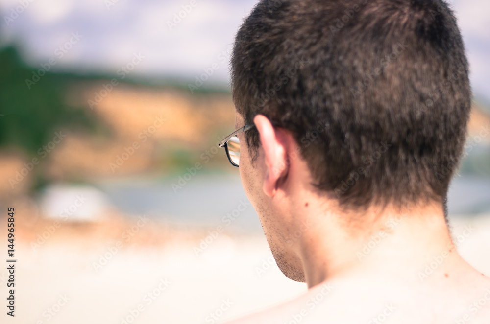 Head of a man in glasses view from behind. A man looking into the distance Head of a man in glasses view from behind. A man looking into the distance