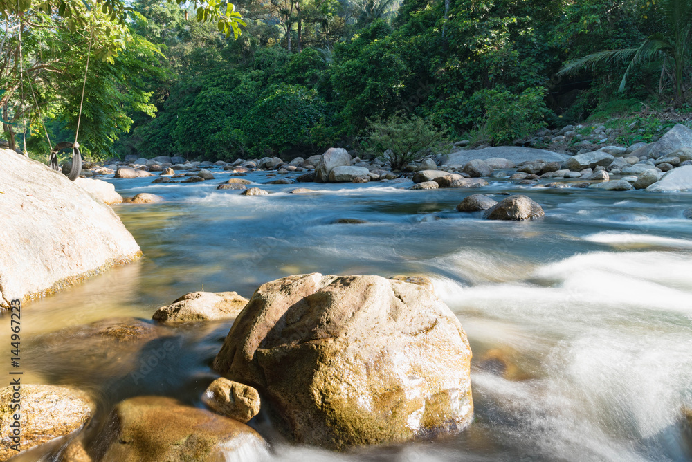 Naklejka premium flowing mountain stream with transparent water and stones