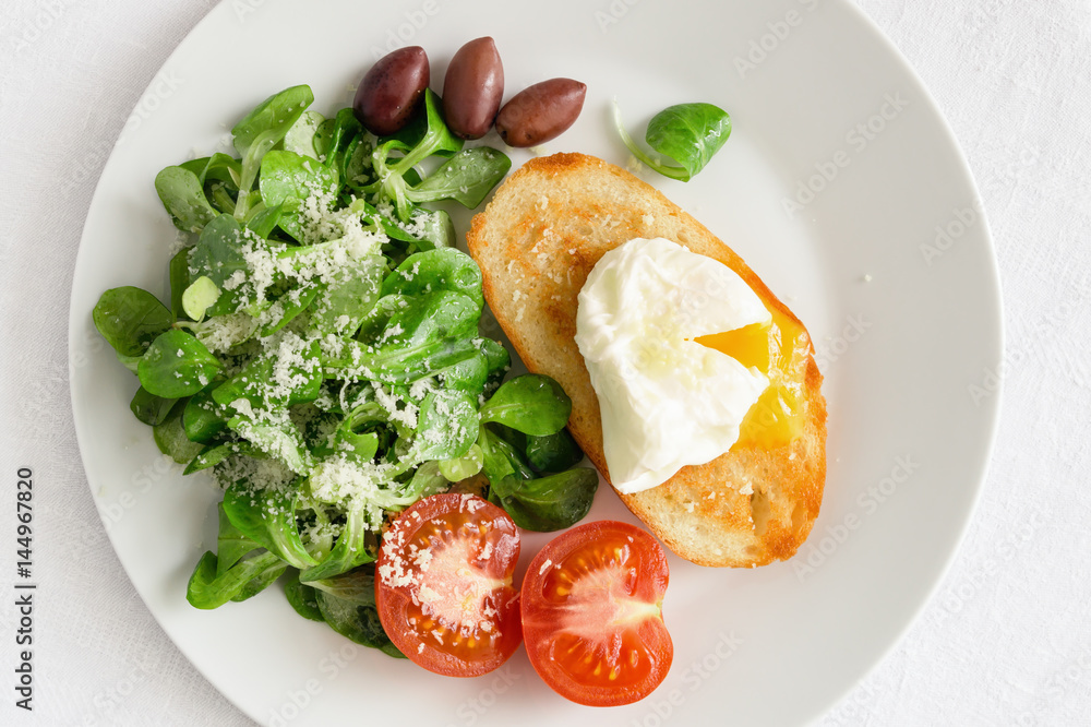 corn salad dressed with olive oil and lemon juice sprinkled with parmesan,  poached egg toast, fresh tomato, and kalamata olives