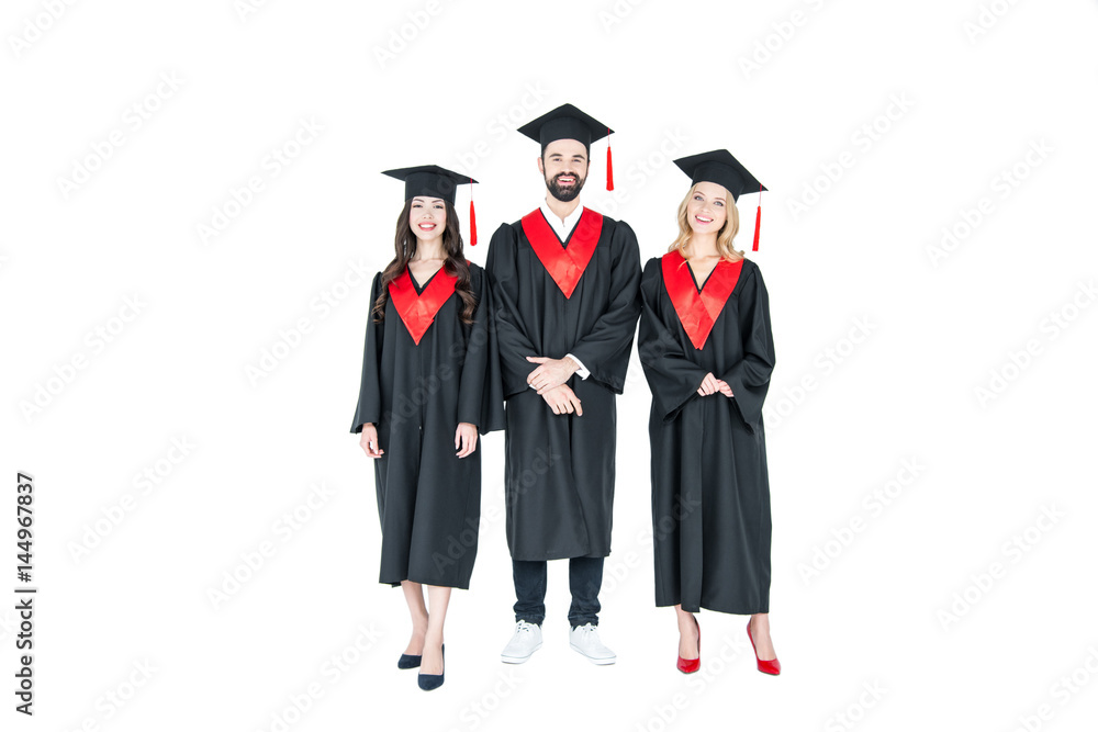 Full length front view of happy students in graduation caps standing together on white Full length front view of happy students in graduation caps standing together on white
