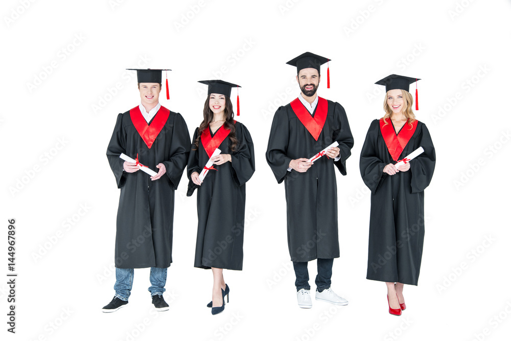 Full length front view of happy students in graduation caps holding diplomas on white Full length front view of happy students in graduation caps holding diplomas on white