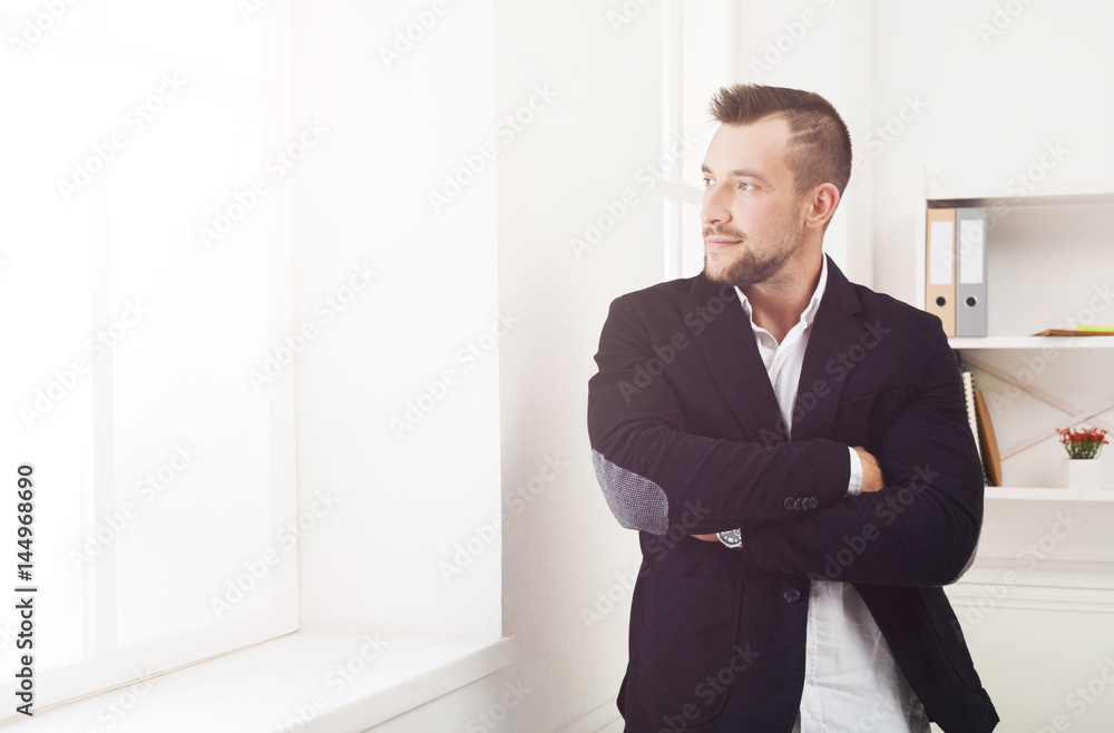 Confident businessman at office near window Confident businessman at office near window