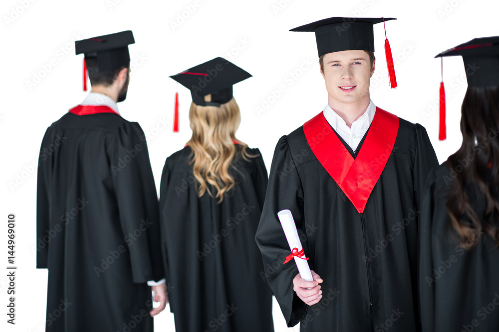 young student in graduation cap with diploma, with friends behind isolated on white young student in graduation cap with diploma, with friends behind isolated on white
