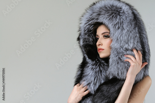 Studio portrait of a girl in a fur hat and bare shoulders