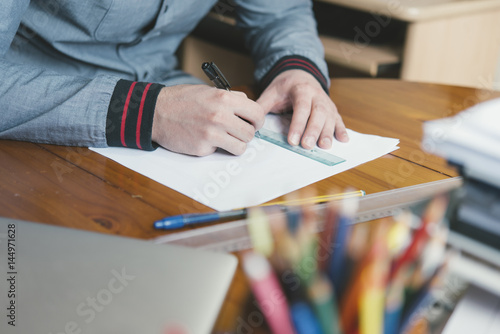 Close-up of man drafting at desk