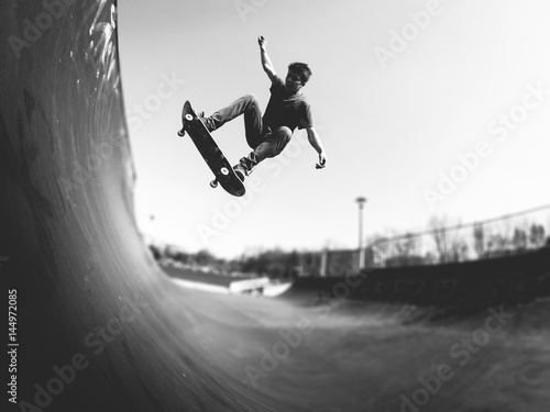 Skateboarder doing ollie on ramp -  black and white photo