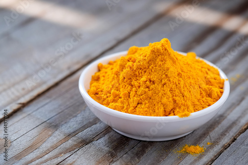 Turmeric powder in white cup.