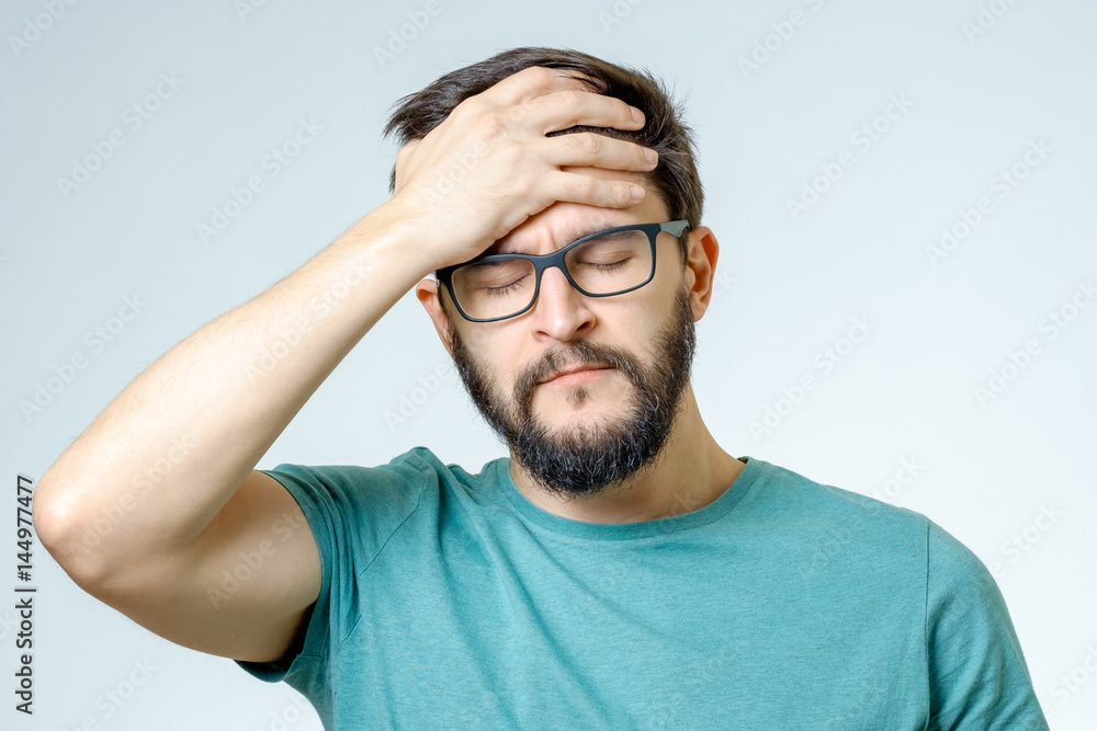 Depressed handsome bearded man touching having a headache Depressed handsome bearded man touching having a headache