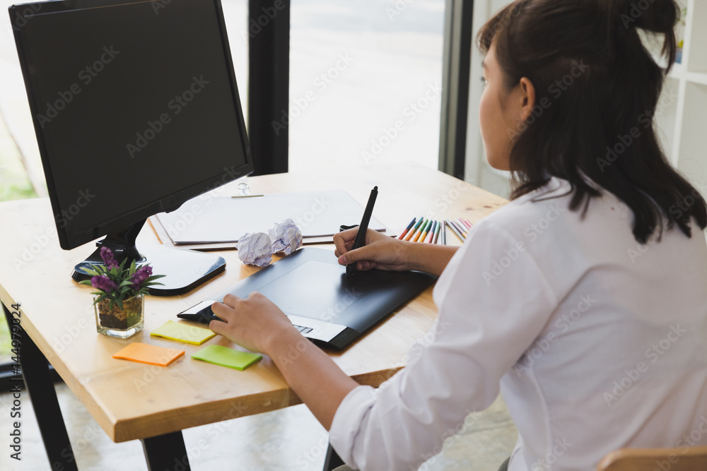 freelance graphic designer drawing on digital tablet. woman working with color swatch catalog samples for selection - Creativity Editor Ideas Concept freelance graphic designer drawing on digital tablet. woman working with color swatch catalog samples for selection - Creativity Editor Ideas Concept