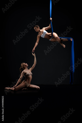 Two sexy girls posing gracefully on aerial silks