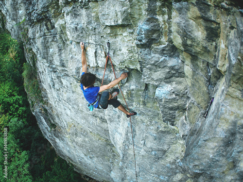 male rock climber on the cliff. man climber climbs on a rocky wall.