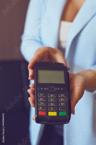 Female hands holding a payment terminal, toned