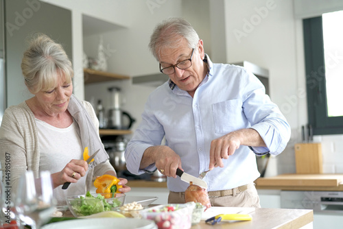 Senior couple cooking together in home kitchen
