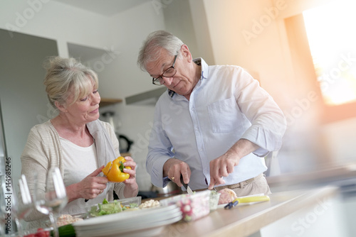Senior couple cooking together in home kitchen