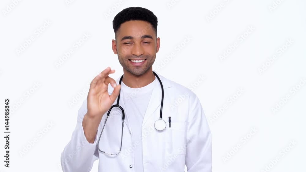 Young african doctor wearing lab coat and showing gesture okay smiling isolated Young african doctor wearing lab coat and showing gesture okay smiling isolated