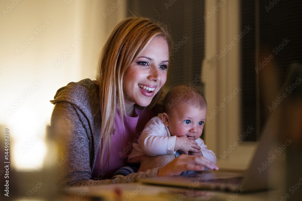 Mother with son in the arms, working on laptop Mother with son in the arms, working on laptop