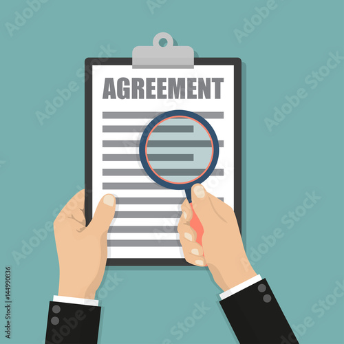 Businessman holding magnifying glass and clipboard with agreement