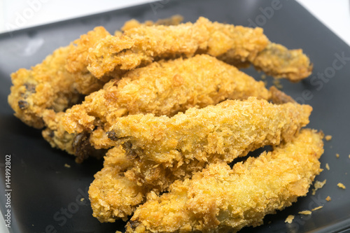 Batter fried fish in egg on black plate