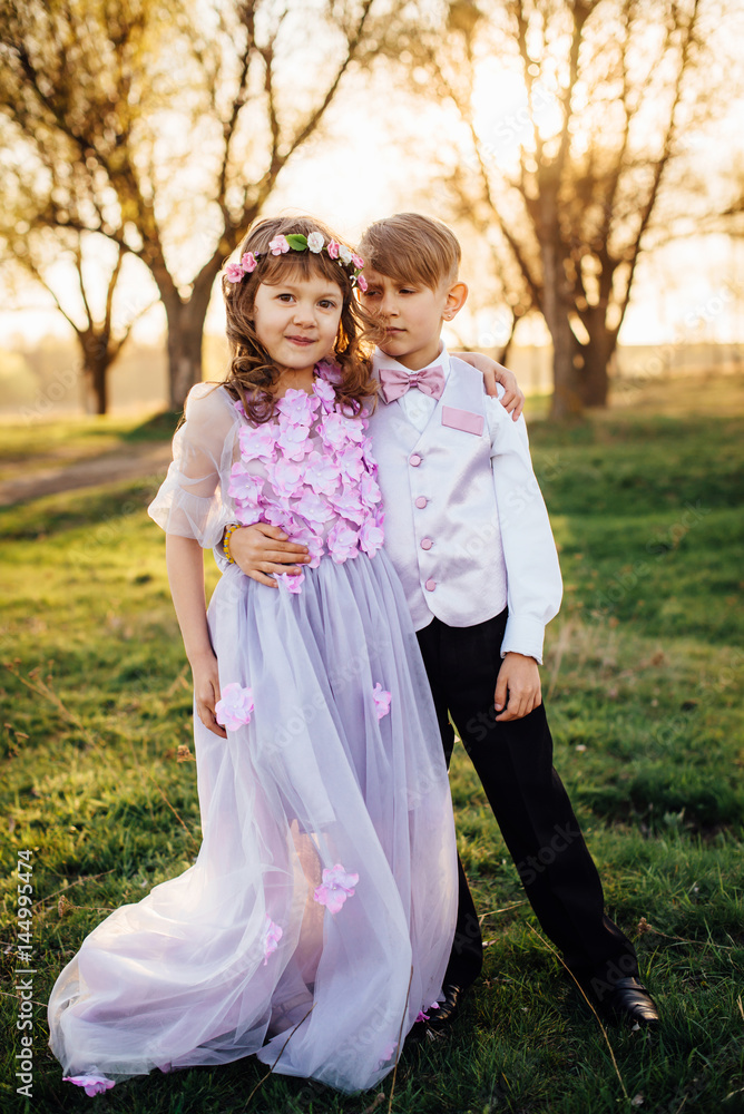 A girl and a boy in smart clothes are walking in the park A girl and a boy in smart clothes are walking in the park