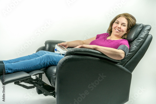 Принти на полотні Pretty middle-age woman sitting in black leather recliner armchair
