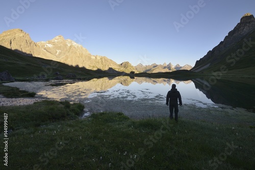 Hiker pauses to observe the Cerces lake, Savoy, France © marcobarone