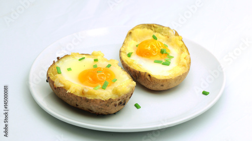 Twice baked potatoes with egg on top on white plate