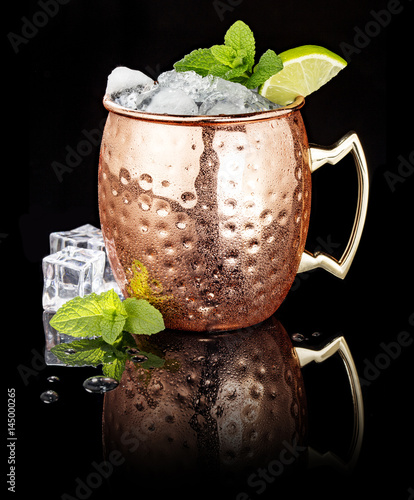 Canvas Print frosty Moscow Mule in a copper cup isolated on black background