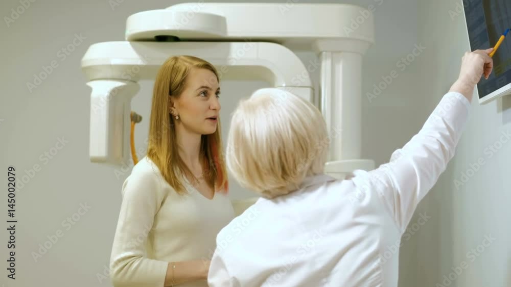 Professional female doctor reading x-ray film of brain and on the phone 4k Professional female doctor reading x-ray film of brain and on the phone 4k