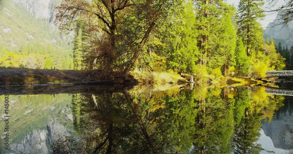 Mountains are reflected in Merced River at Yosemite National Park, California. Half Dome and Sentinel Bridge can be seen in the distance. Mountains are reflected in Merced River at Yosemite National Park, California. Half Dome and Sentinel Bridge can be seen in the distance.