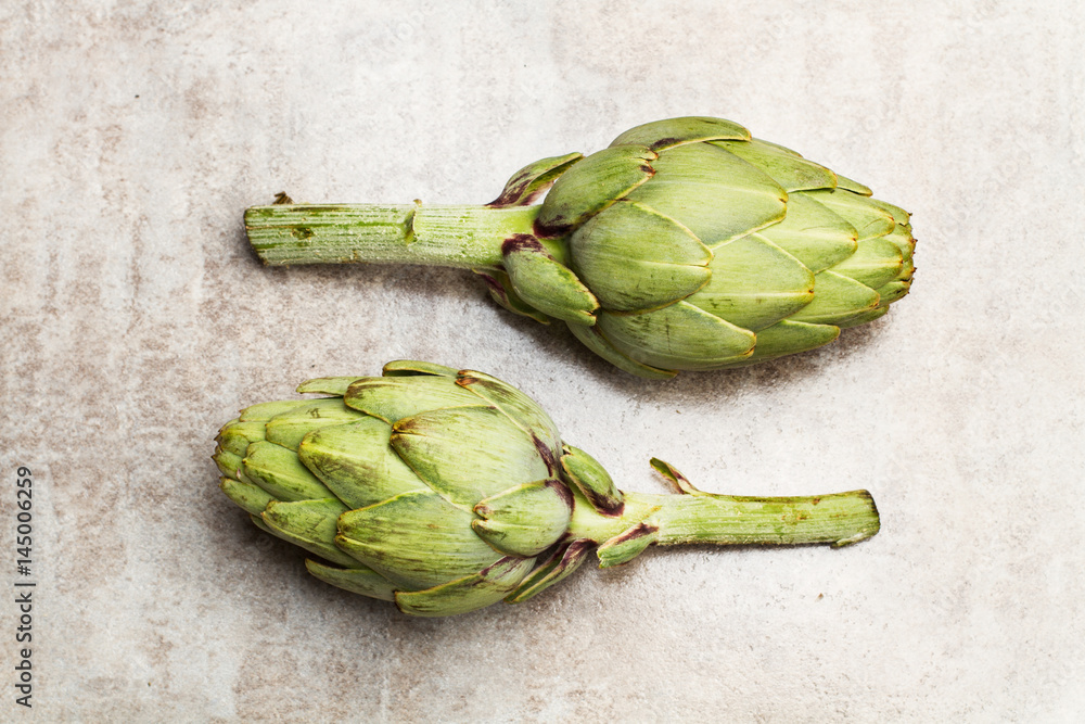 Obraz premium Alcachofas entera sobre mesa gris. Vista superior