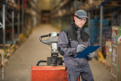 Caucasian worker controling stock in warehouse