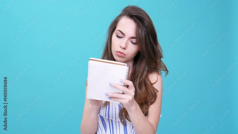Young woman drawing in the notebook with pencil isolated Young woman drawing in the notebook with pencil isolated