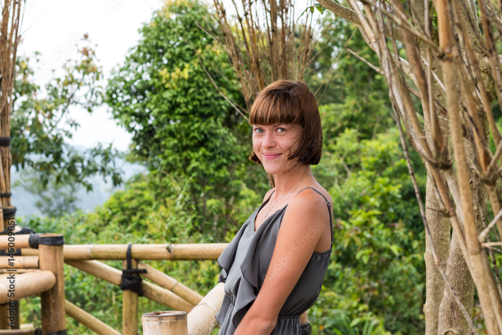 Portrait of happy young woman on the mountains background. Tropical island Bali, Indonesia. Lady in travel. Portrait of happy young woman on the mountains background. Tropical island Bali, Indonesia. Lady in travel.