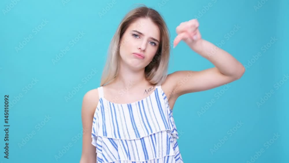 Young woman showing dislike gesture isolated Young woman showing dislike gesture isolated
