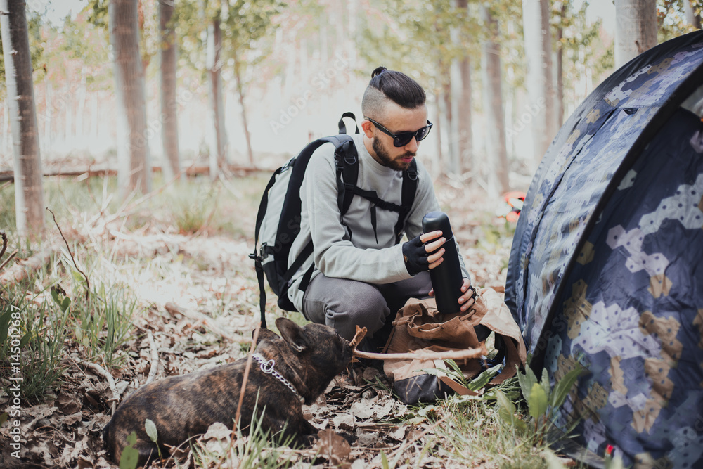 Young backpacker enjoying his dog in the mountain Young backpacker enjoying his dog in the mountain