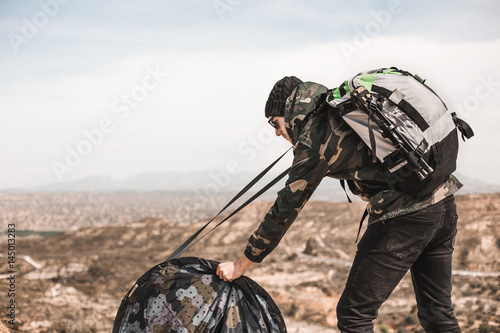 Backpacker man riding the tent in the mountain