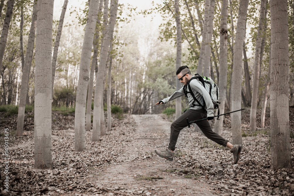 Young backpacker man running through the forest Young backpacker man running through the forest
