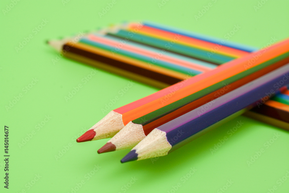 Colored pencils on a green background Colored pencils on a green background