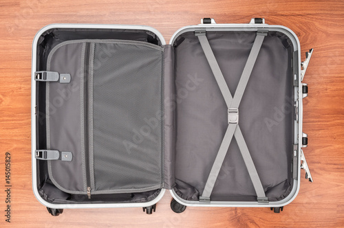 Opened empty travel bag on wooden floor
