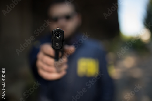 FBI agent pointing a gun at you