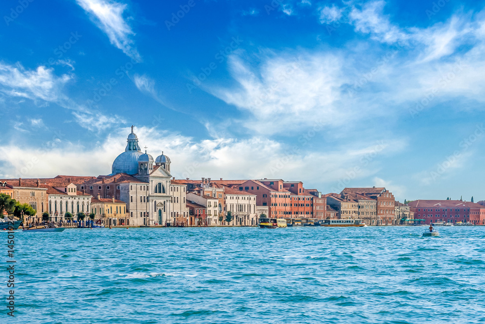 Majestic landscape view from the sea to old cathedral of Santa Maria della Salute in Venice, Italy. With amazing colorful blue sky and white clouds.