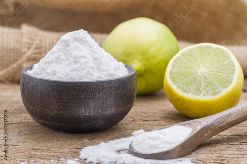 Baking soda with lemon on wooden background