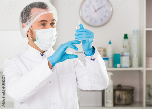 Male nurse preparing injection
