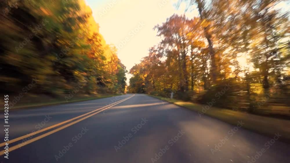 Autumn POV driving shot of the Blue Ridge Parkway through North Carolina at sunset