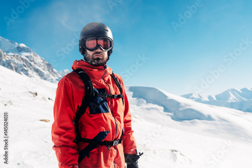 serious snowboarder is standing in the red suit