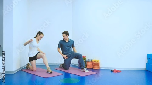 Rehabilitologist show the sports exercises to patient in rehabilitation center photo